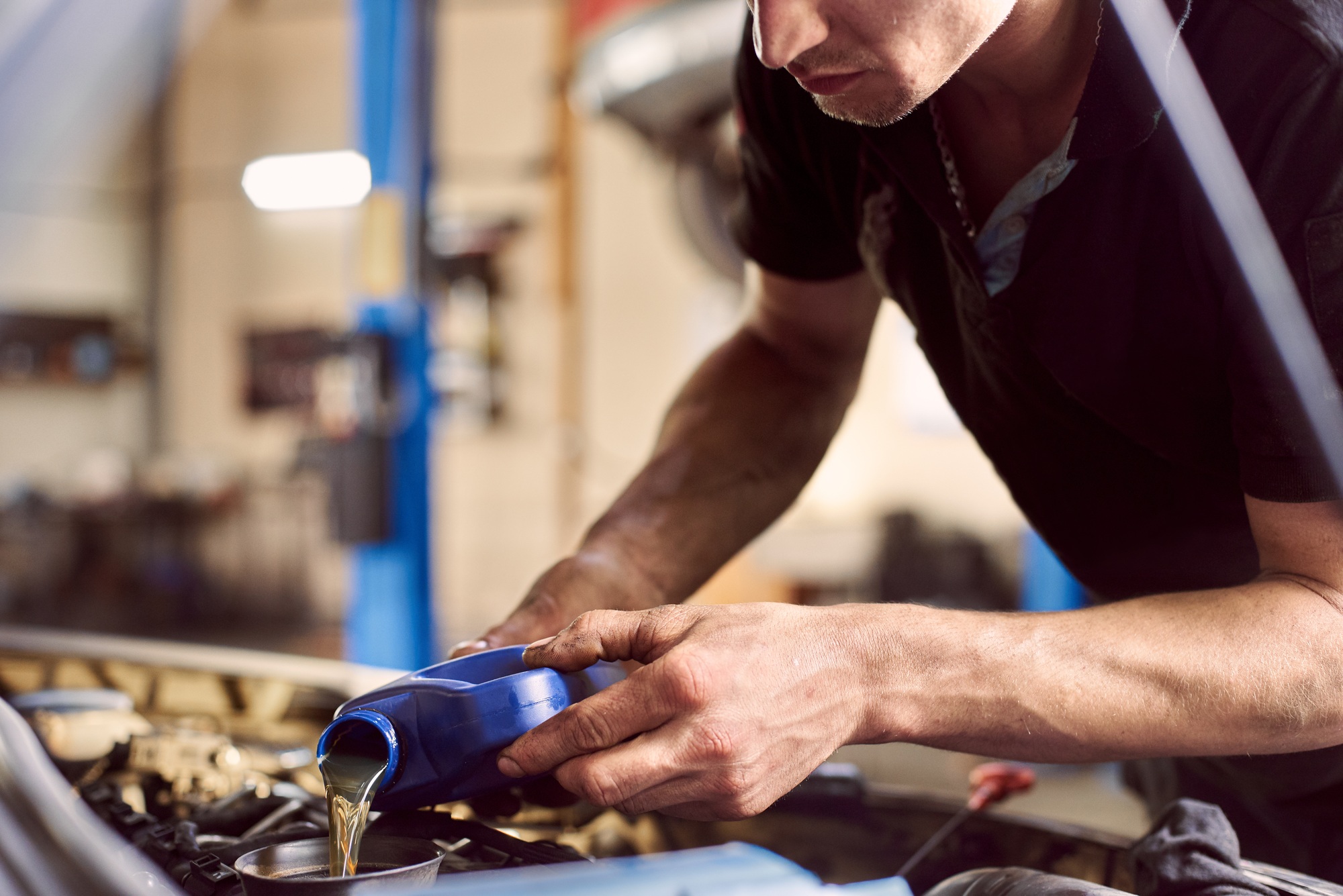 Oil replacing maintenance. Car engine lubricants changing in auto service.
